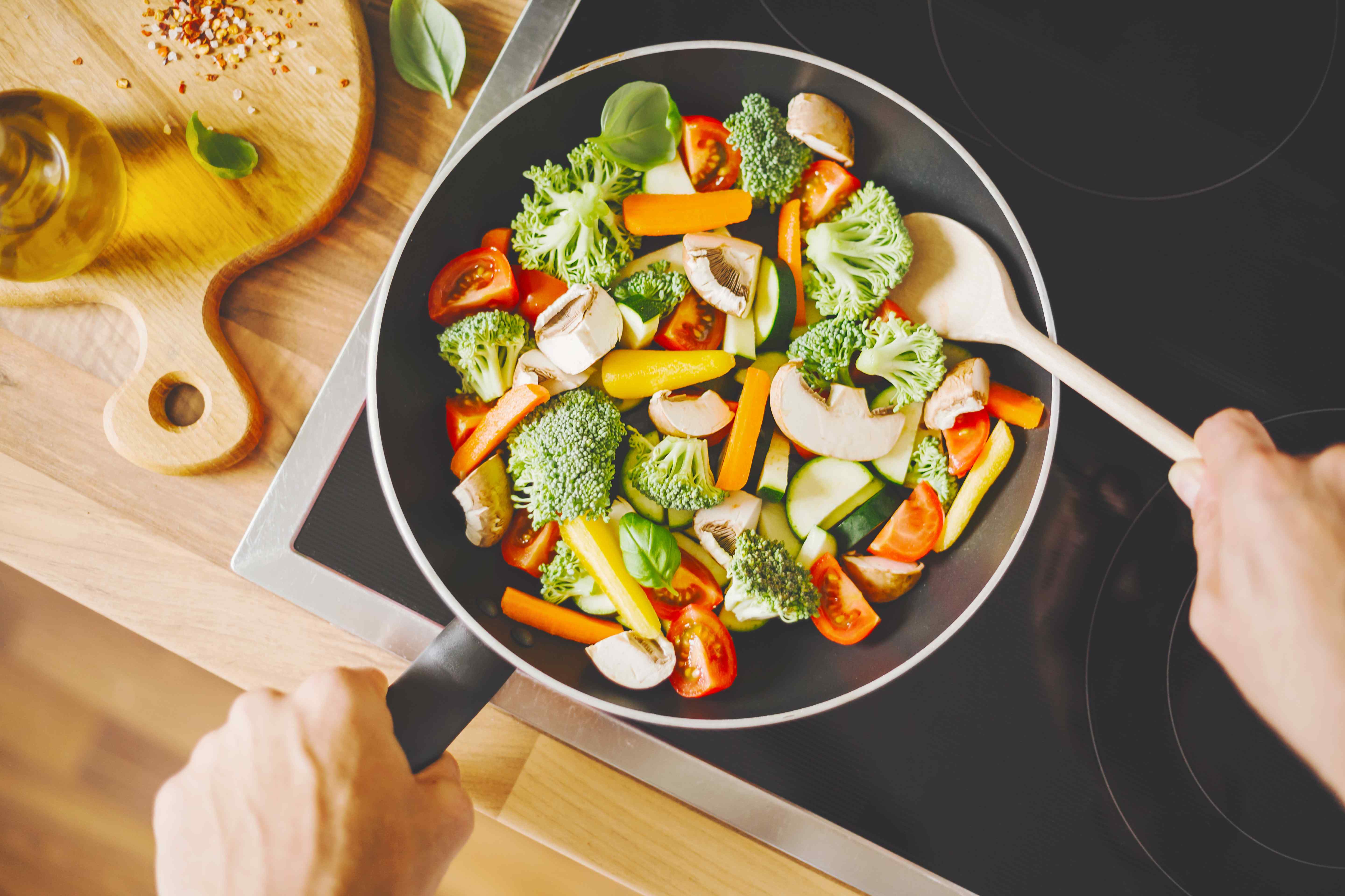 a vegan man cooking fresh vegetables